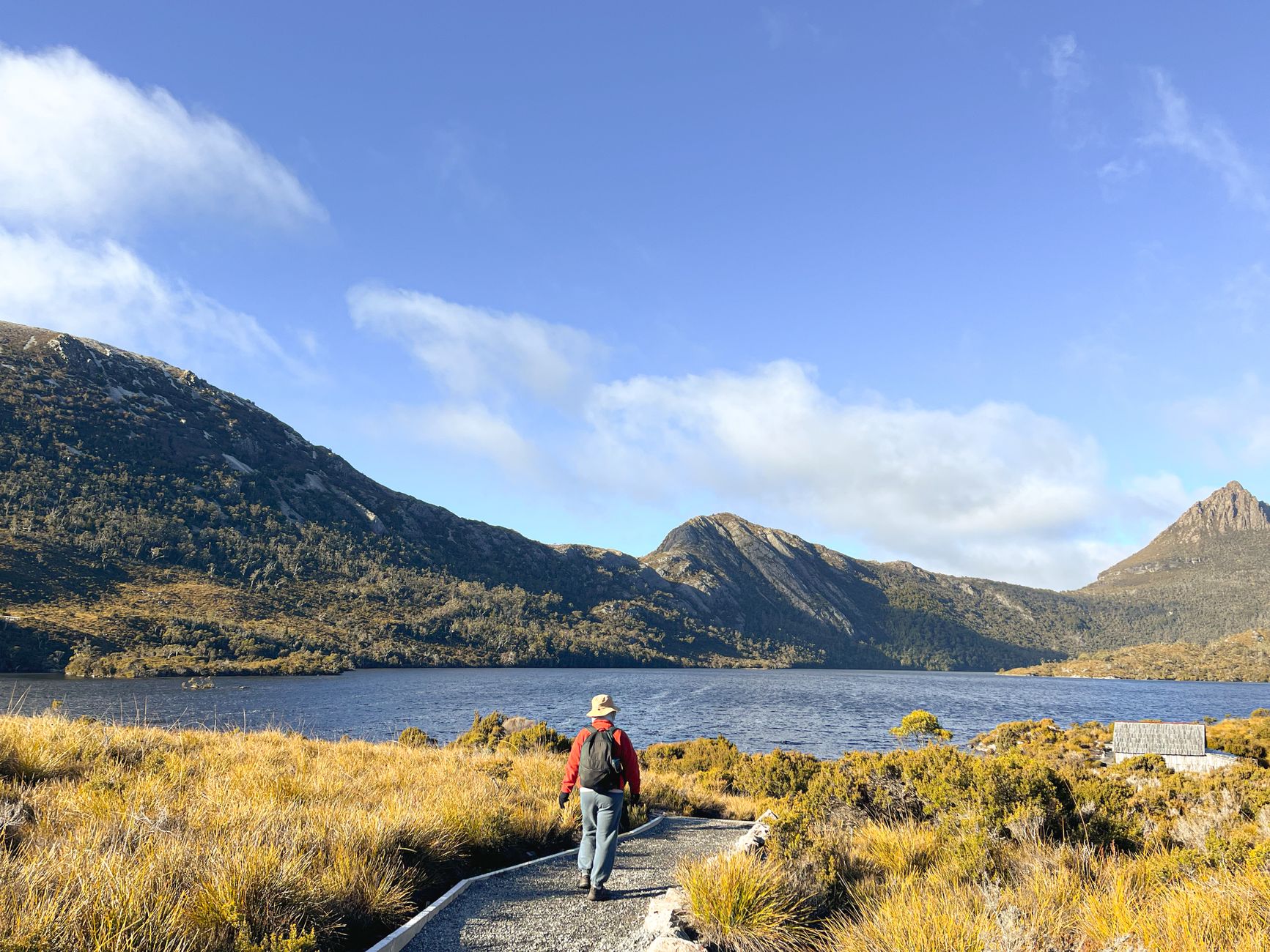 Turysta na szlaku z widokiem na Cradle Mountain w słoneczny dzień